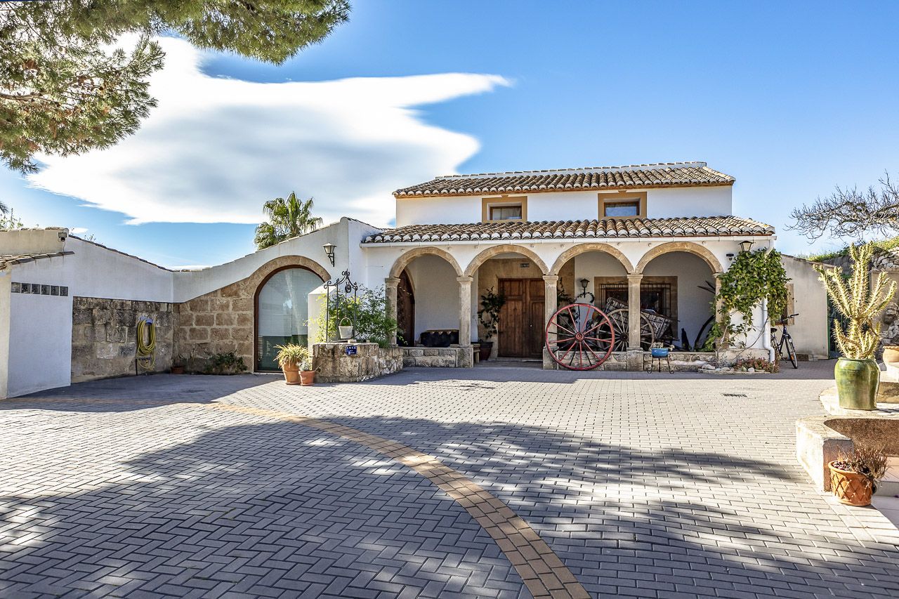 The white villa of the Academia Neerlandesa with arches and palm trees in Jávea